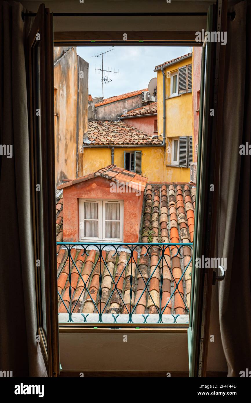 Blick auf das alte Nizza von der Dachterrasse aus. Dächer aus Fliesen und Ockerwänden im traditionellen italienischen Stil. Stockfoto