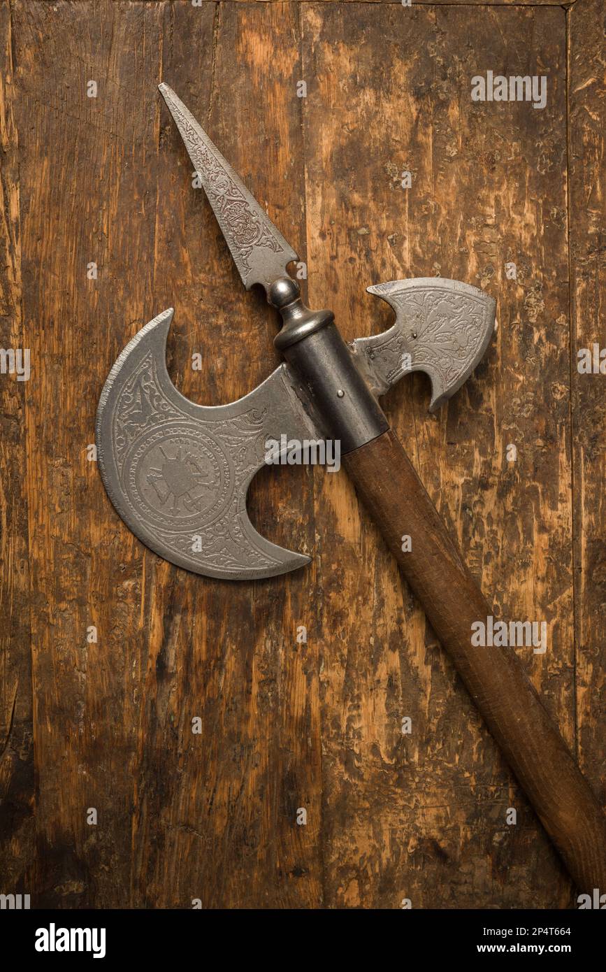 Mittelalterliche Kampfaxt mit Holzgriff und Stahlklinge mit spanischen Gravuren Stockfoto