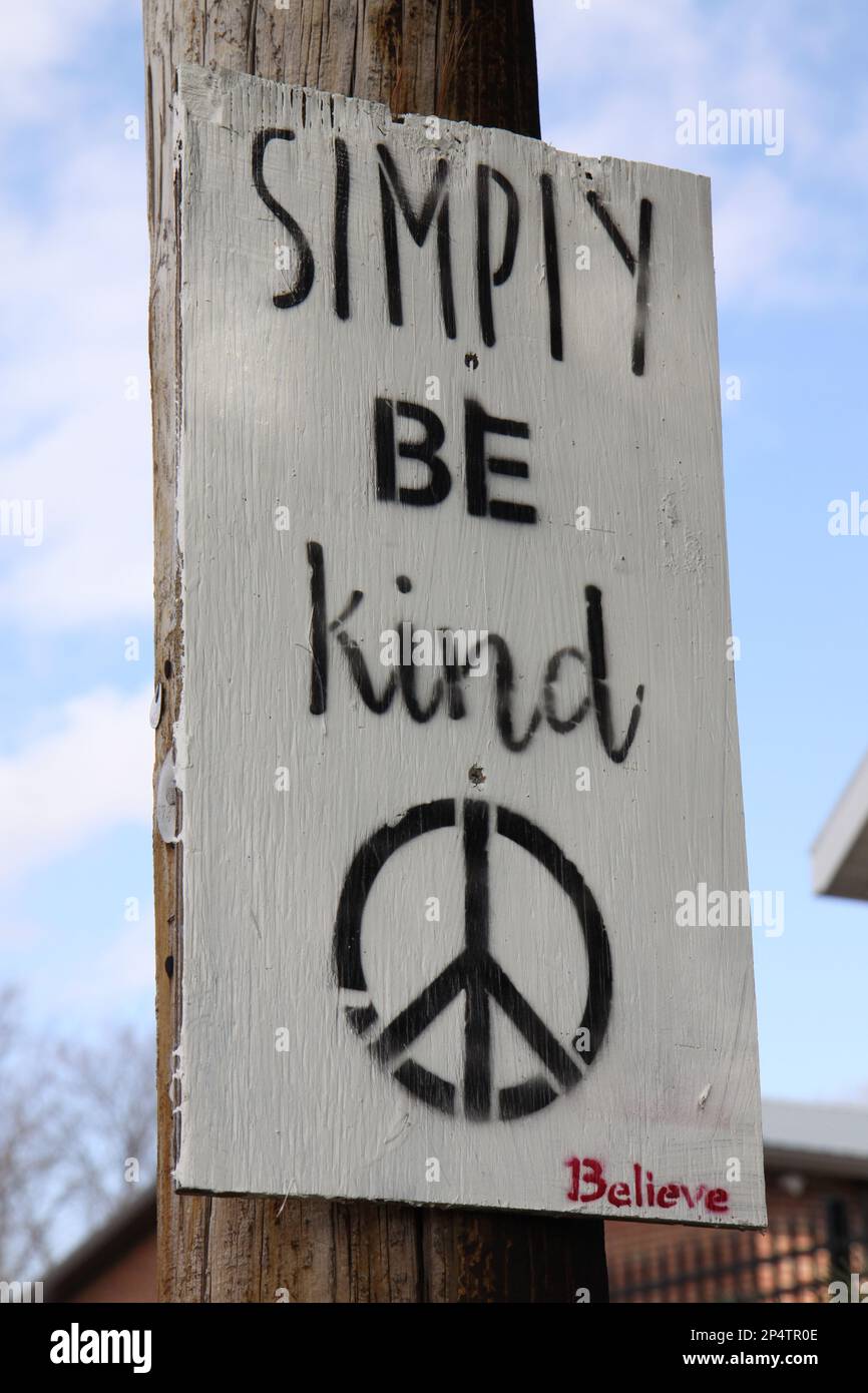 Das Schild „einfach freundlich sein“ ist an einem Telefonmast in einer Seitenstraße angebracht. Stockfoto