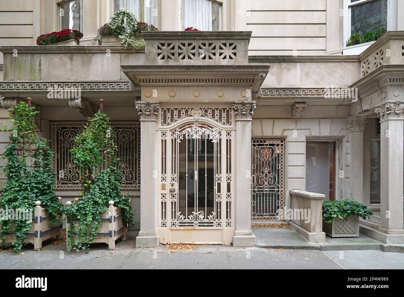 Manhattan, eleganter Eingang zum Stadthaus mit kunstvoll verziertem schmiedeeisernem Grill an der Tür Stockfoto