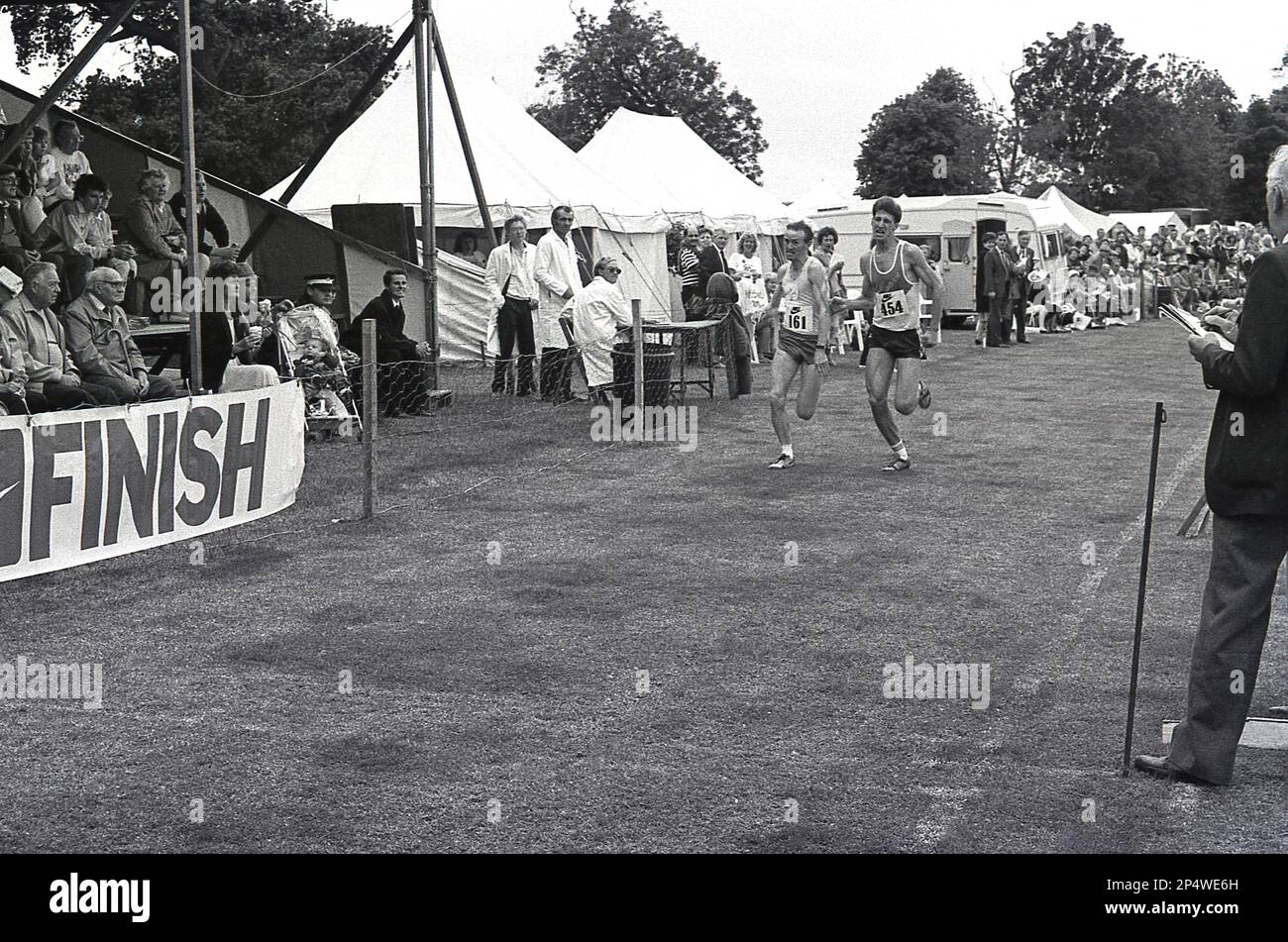 1989, das Ende eines Park-Running-Rennens, England, Großbritannien... das Bild zeigt zwei männliche Athleten, die nebeneinander springen, um als erste die Ziellinie zu erreichen und den Sieg zu erringen. Stockfoto
