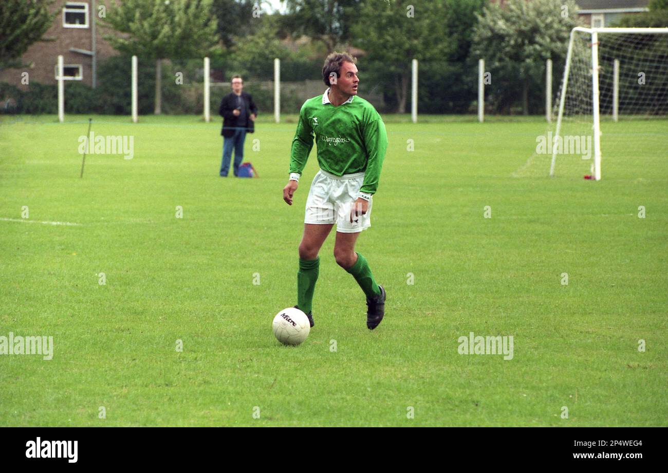 1989, Amateurfußballer, ein Mann mit grünem Trikot, mit Ball zu Füßen, spielt draußen auf einem Fußballrasenplatz, England, Großbritannien. In früheren Epochen hätte man keine grünen Fußballtrikots gesehen, da die Farbe traditionell die Farbe des Trikots des Torhüters war und es daher mit einem Außenfeldspieler in Konflikt geraten wäre. Stockfoto