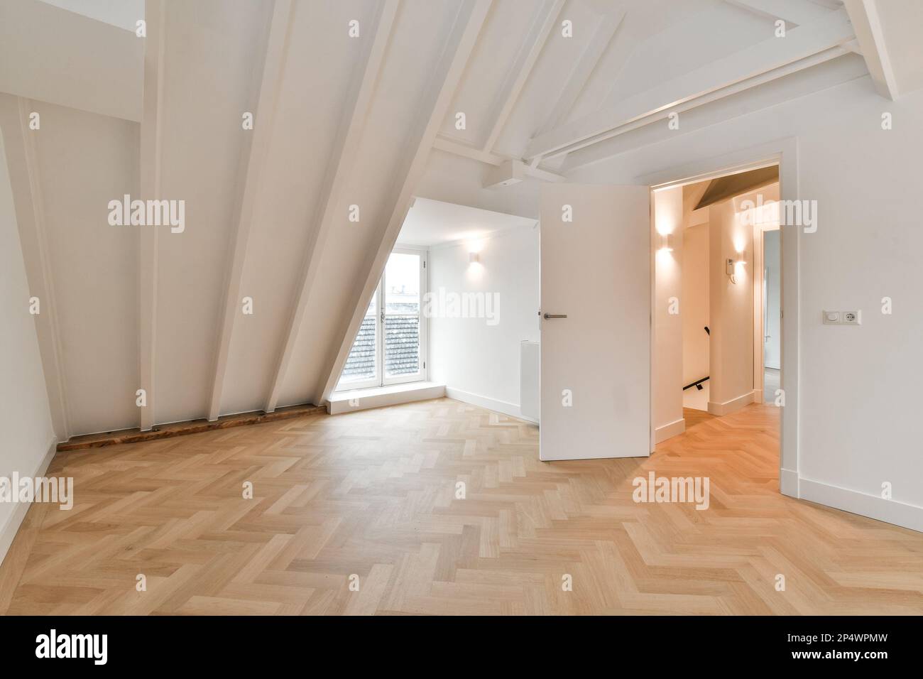 Ein leeres Zimmer mit Holzfußboden und weißen Wänden in der Gegend ist sehr sauber, aber es ist schwer zu erkennen, wie Stockfoto