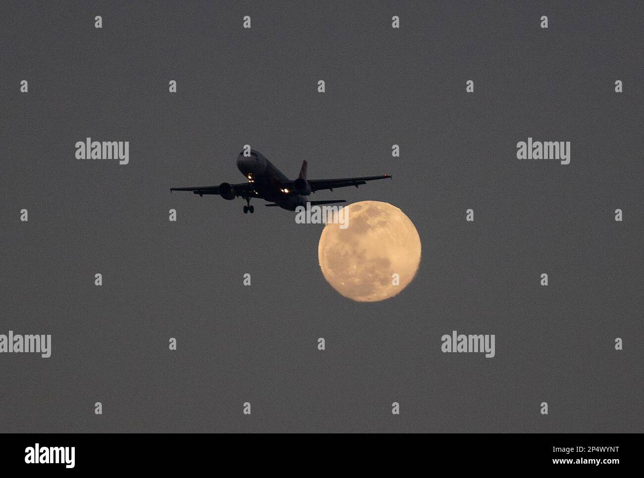 Neu-Delhi, Indien. 6. März 2023. Ein Flugzeug mit dem Vollmond hinter sich in Neu-Delhi, Indien, 6. März 2023. Kredit: Javed Dar/Xinhua/Alamy Live News Stockfoto