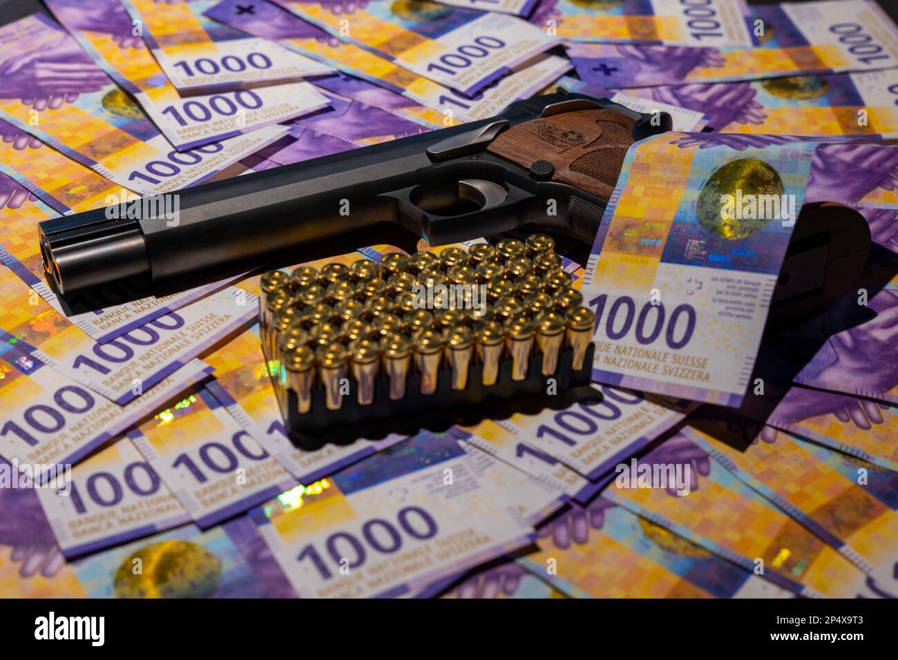 Elegante halbautomatische 9mm-Pistole mit Schweizer Helvetia-Symbol auf Schweizer 1000-Franken-Banknote und Munition in der Schweiz. Stockfoto