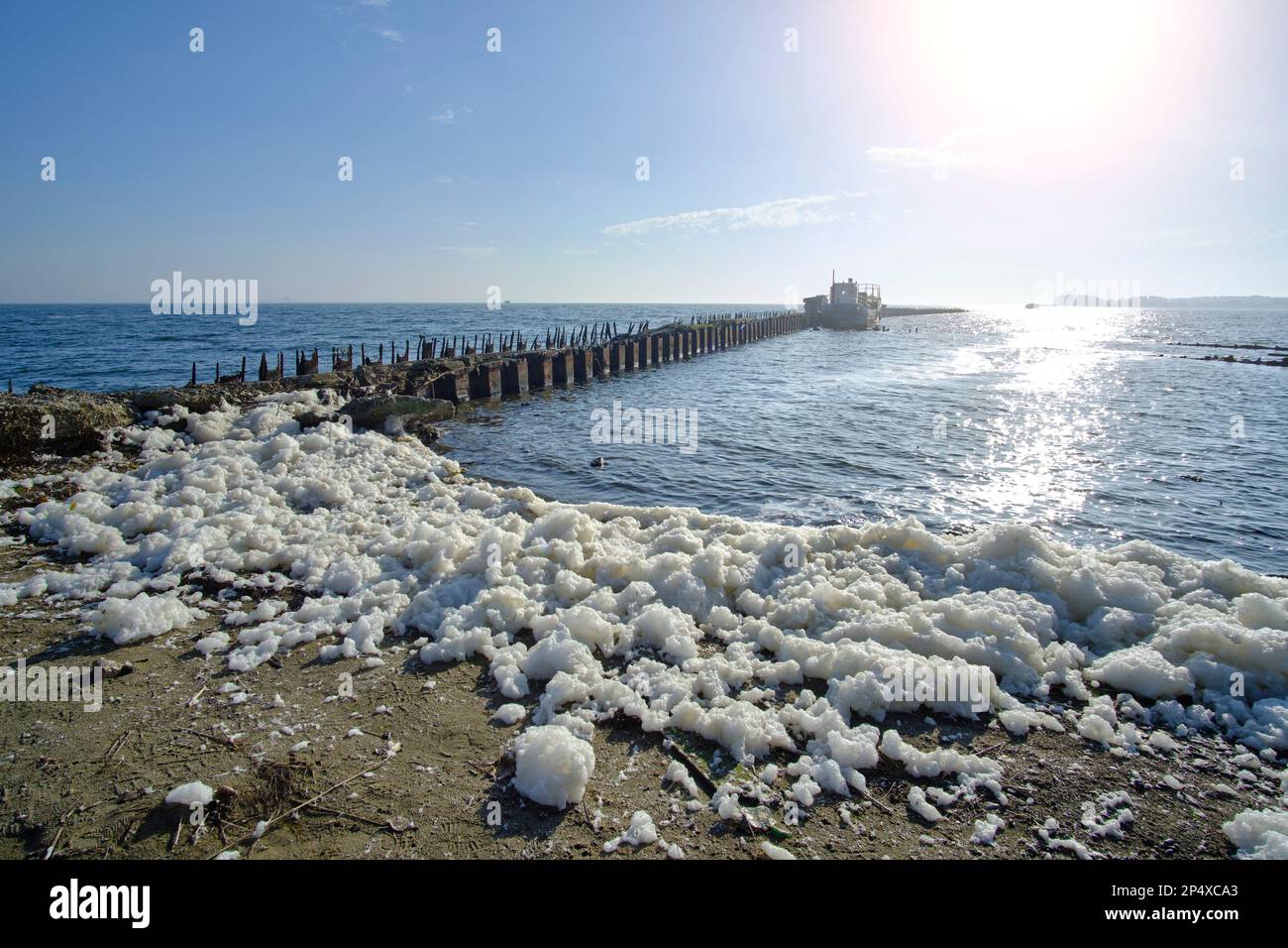 Die Ostsee wurde vor dem Hintergrund eines verlassenen Piers angespült Stockfoto