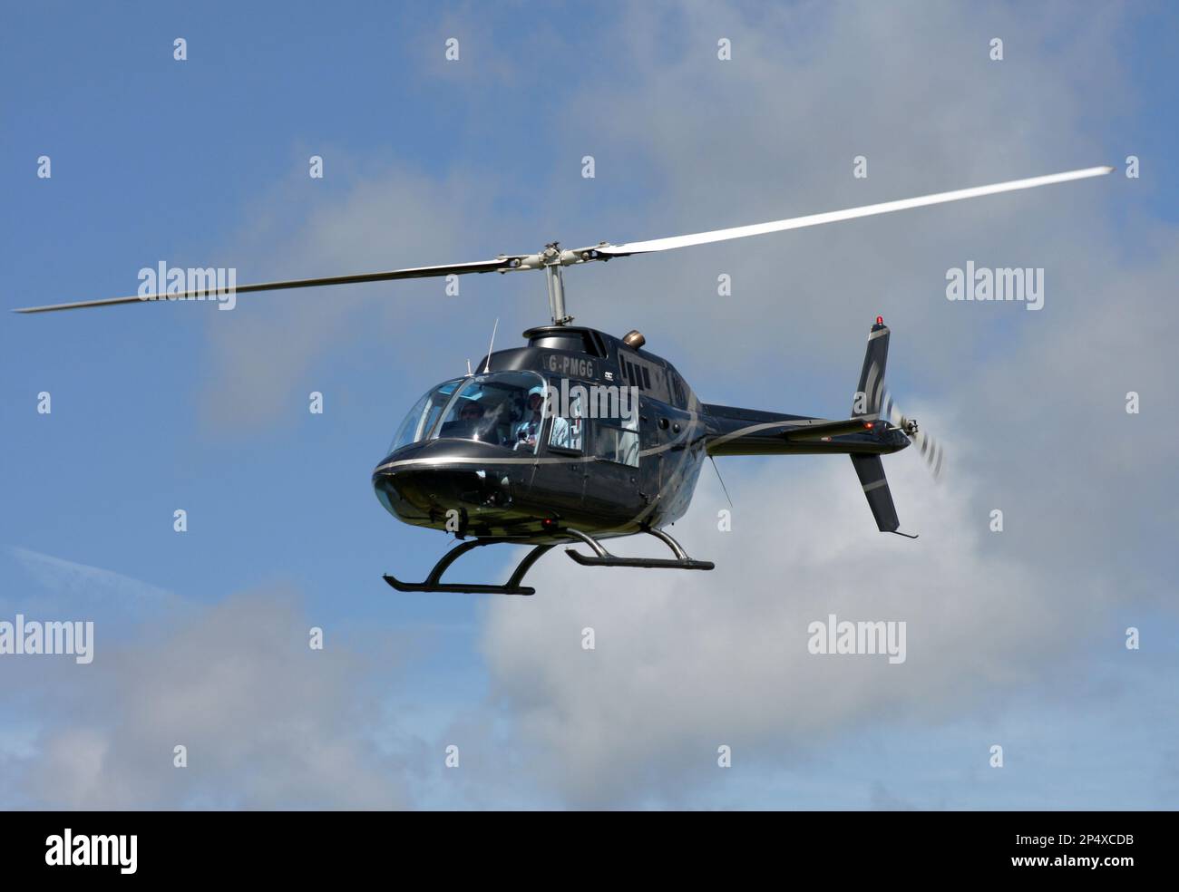 Ein Agusta-Bell ab-206A JetRanger Hubschrauber fliegt auf einem Flugplatz in East Sussex entlang der Landebahn Stockfoto