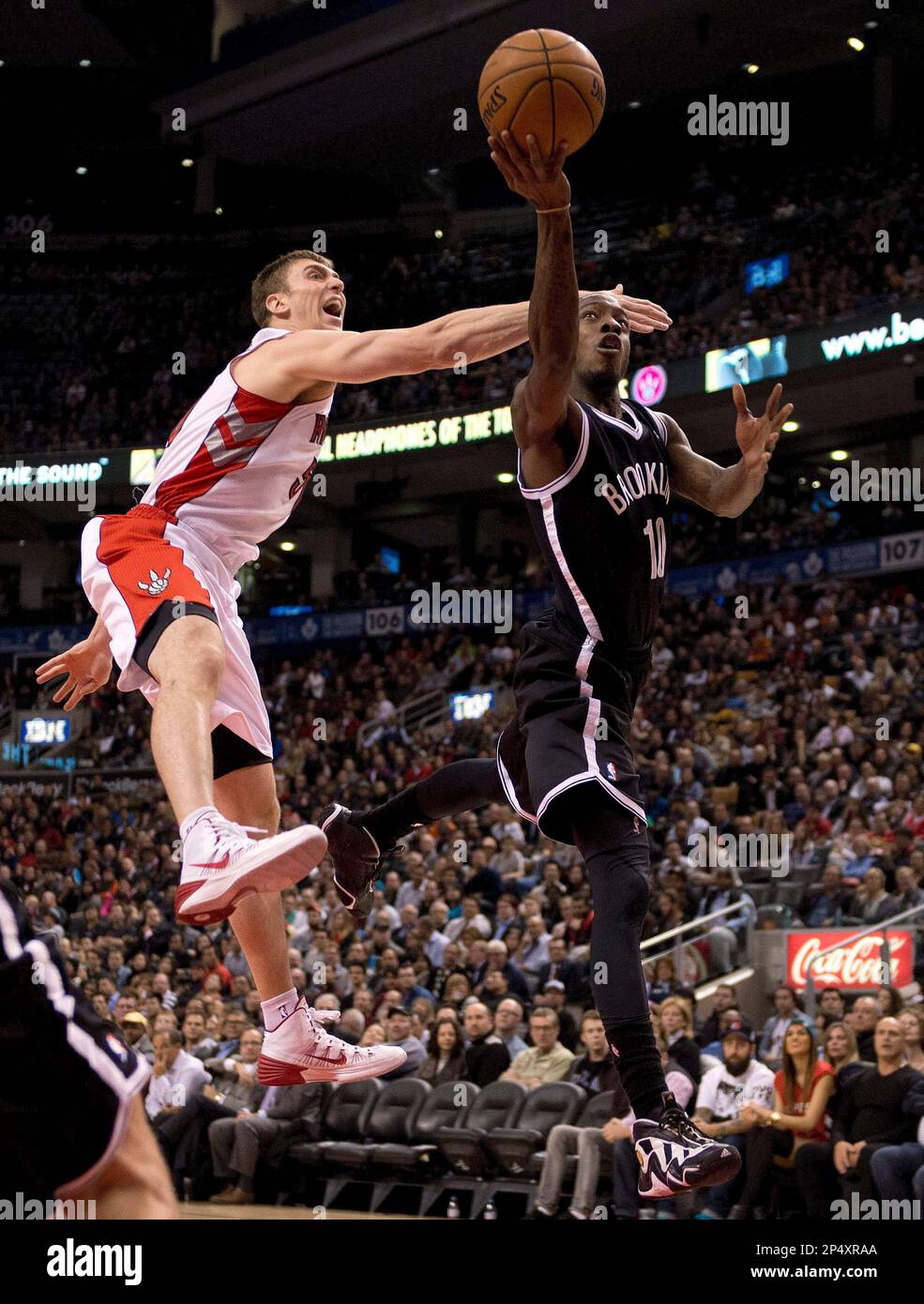 Brooklyn Nets guard Tyshawn Taylor (10) drives to the hoop past Toronto Raptors forward Tyler Hansbrough (left) during the second half of an NBA basketball game in Toronto on Tuesday, Nov. 26, 2013. (AP Photo/The Canadian Press, Frank Gunn) Stockfoto