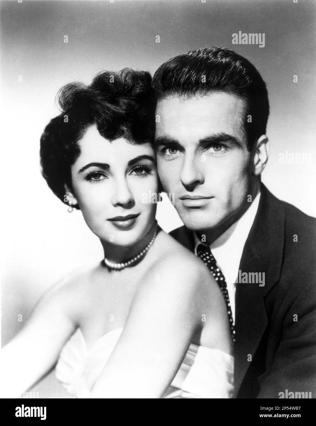 1951 , USA : die Filmschauspielerin ELIZABETH TAYLOR mit MONTGOMERY CLIFT (1920 - 1966 ) an Einem PLATZ IN DER SONNE ( UN posto al Sole - Una tragedia americana ) Von George Stevens aus einem Roman von Theodore Dreiser und dem Stück von Patrick Kearney - KINO - FILM - LIZ - perla - perle - Perlenkette - collana - Orechini - Ohrtropfen - Juwelen - Schmuck - gioiello - gioielli - umarmen - abbraccio --- Archivio GBB Stockfoto