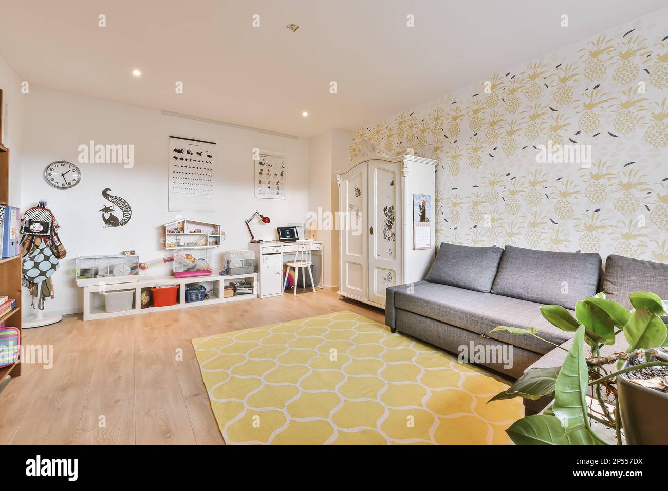 Amsterdam, Niederlande - 10. April 2021: Ein Wohnzimmer mit gelb-weißen Tapeten an den Wänden, eine graue Couch und ein graues Sofa Stockfoto