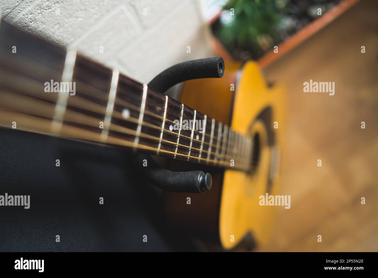 Akustikgitarre lehnt sich an die Wand, Musikkonzept. Hochwertiges Foto Stockfoto