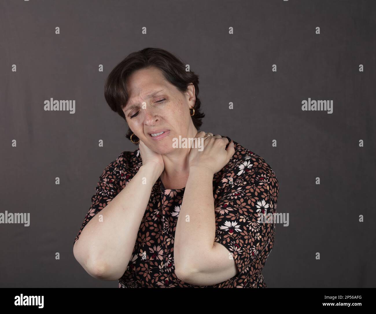 Eine Frau, die Hals- und Nackenschmerzen hat Stockfoto