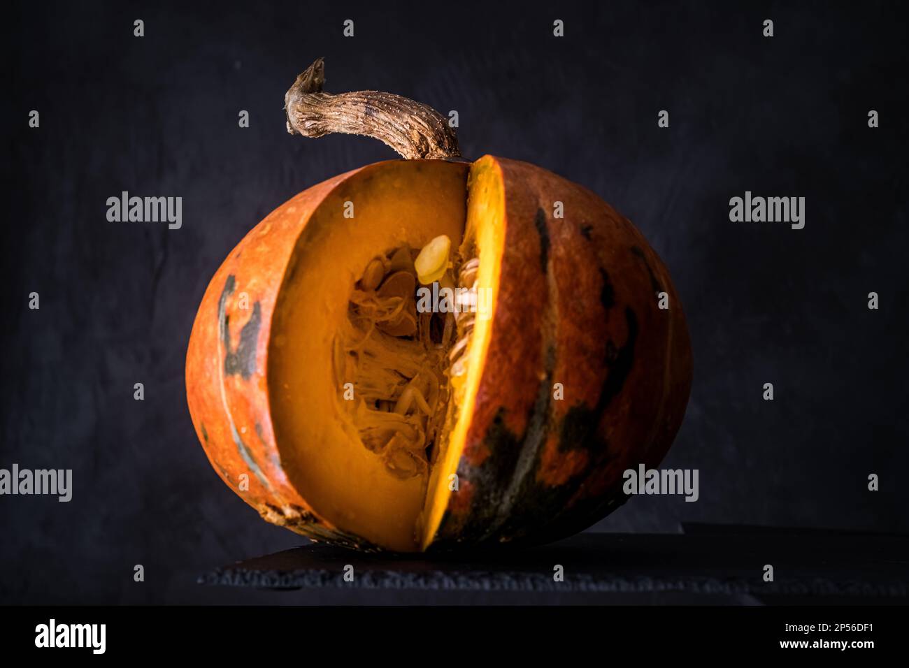 Nahaufnahme eines auf dunklem Schieferhintergrund isolierten OrangenKürbiss. Platz für Text kopieren Stockfoto