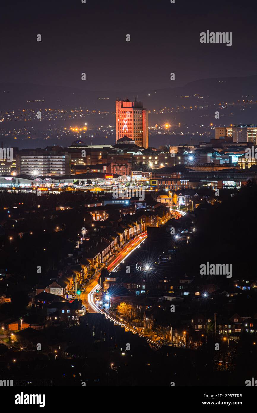 Ein abendlicher Blick auf das Stadtzentrum von Oldham, Greater Manchester, mit dem Bezirk Glodwick im Vordergrund, wie vom Harsthead Pike in Mossley aus gesehen. Stockfoto