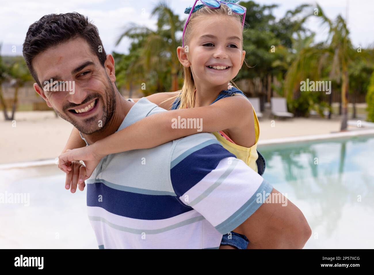 Fröhlicher Vater und Tochter, die sich am Pool umarmten Stockfoto