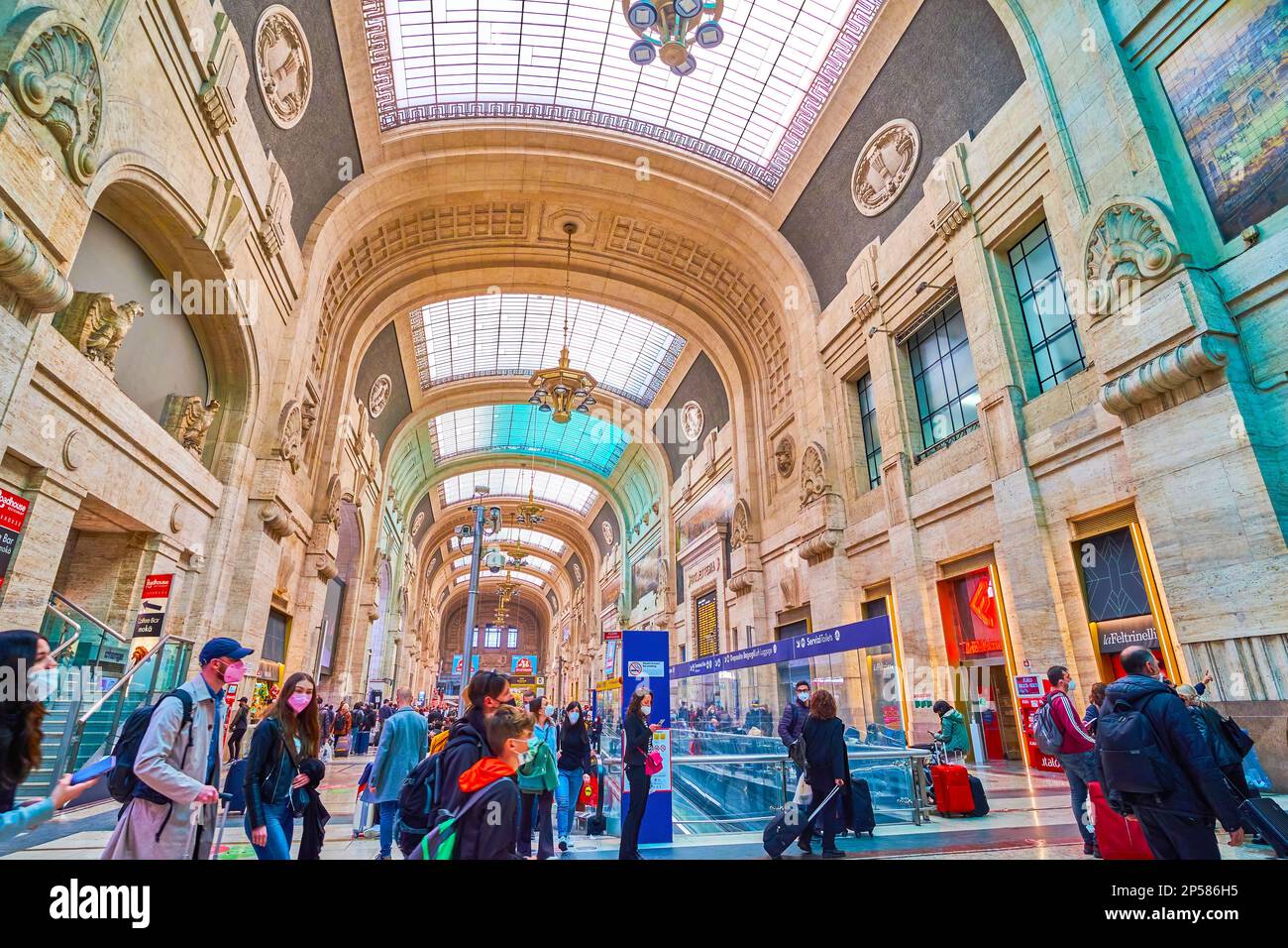 MAILAND, ITALIEN - 11. APRIL 2022: Die überfüllte Hauptgalerie des Bahnhofs Mailand Centrale, die im Art déco-Stil fertiggestellt wurde, wurde am 11. April in Mailand, Italien, eröffnet Stockfoto