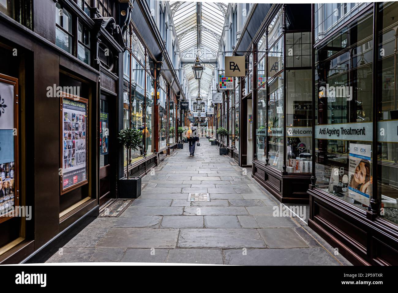 Älterer Gentleman im Anzug, der nach Schließung im Sommer durch die historische Morgan Arcade spaziert Stockfoto