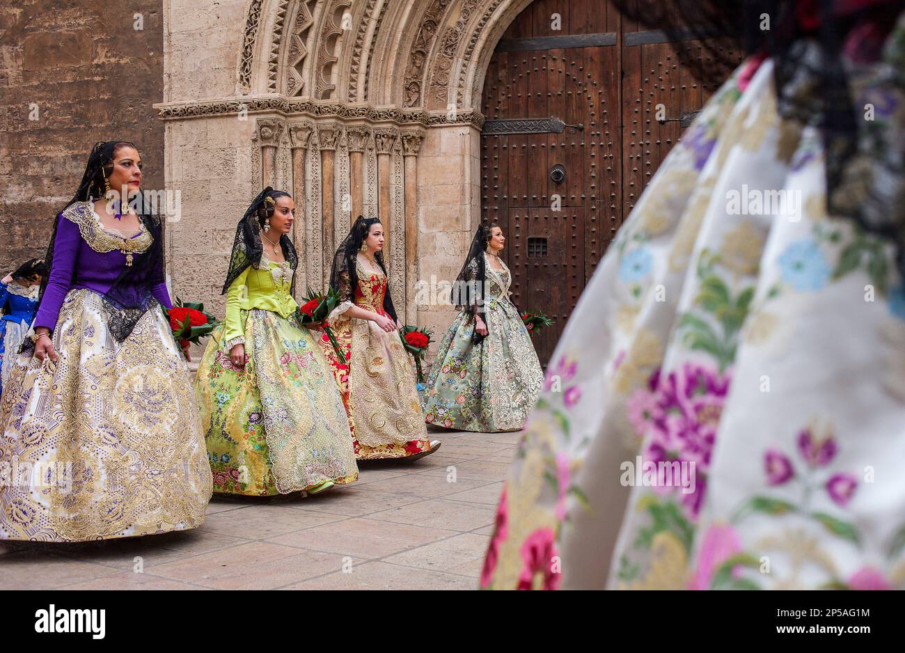 Blumenparade, Leute mit Blumengedanken an 'Virgen de los desamparados', Fallas-Festival, Plaza de l'Almoina, Valencia Stockfoto