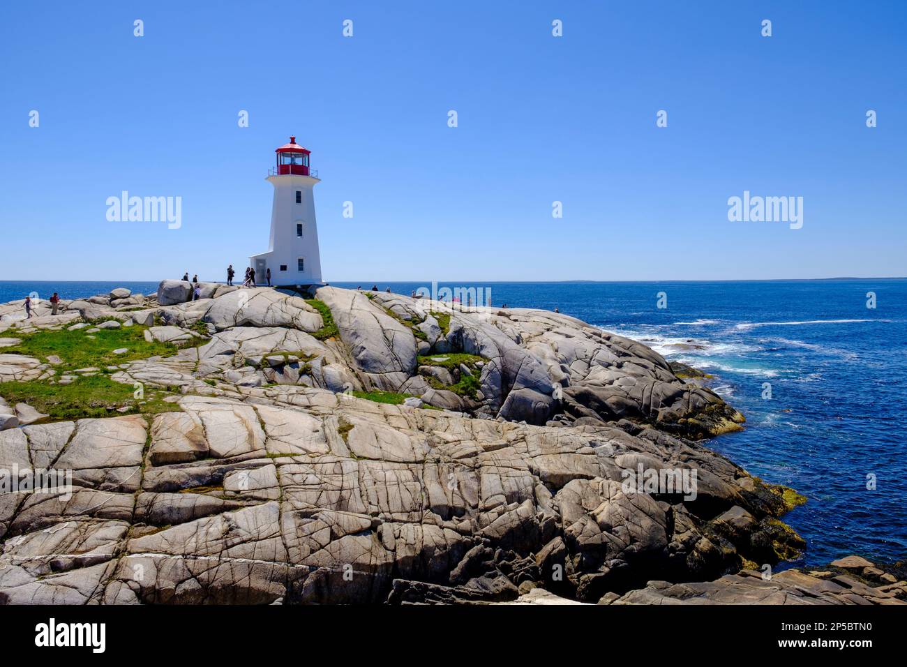 Touristen auf Felsformationen am Leuchtturm Peggy's Cove, Nova Scotia, Kanada Stockfoto