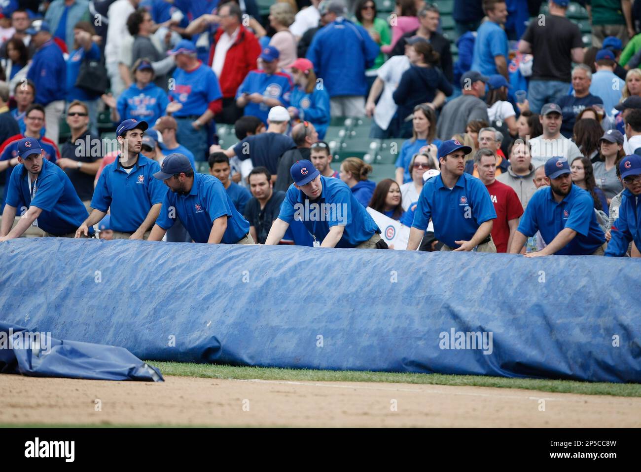 CHICAGO, IL - MAY 2: The Chicago Cubs grounds crew members roll out a large tarp on the field after the game between the Chicago Cubs against the Arizona Diamondbacks at Wrigley Field on May 2, 2010 in Chicago, Illinois. The Cubs defeated the Diamondbacks 10-5. (AP Photo/Scott Boehm) Stockfoto