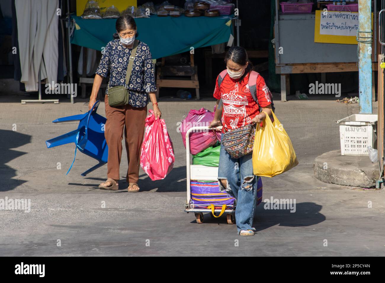 SAMUT PRAKAN, THAILAND, FEBRUAR 13 2023, Eine Frau verlässt den Markt mit einem Wagen voller Taschen Stockfoto