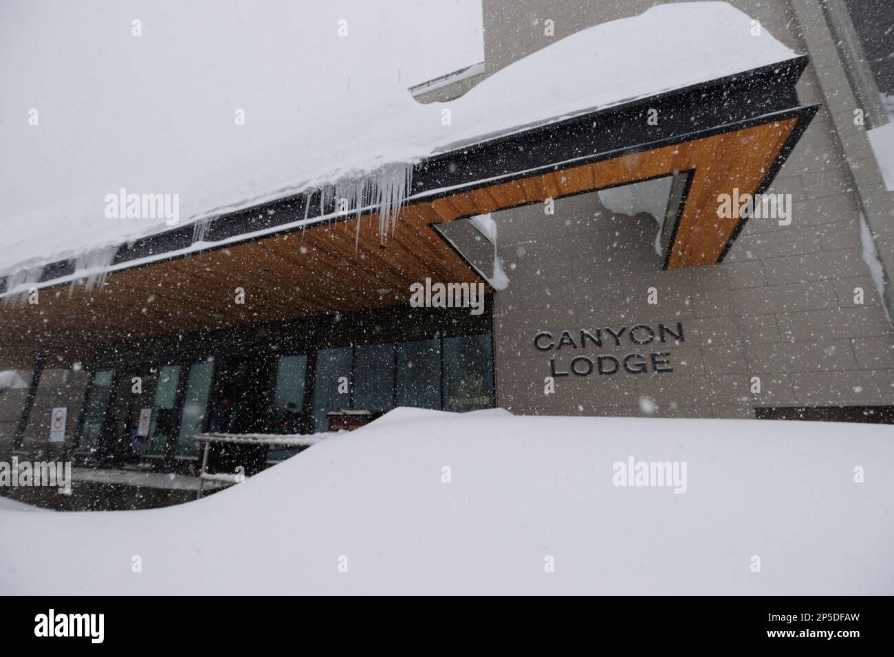 Auf dem Dach der Canyon Lodge sammelt sich während eines Schneesturms im Skigebiet Mammoth Mountain in den Bergen der östlichen Sierra Nevada tiefer Schnee. Stockfoto