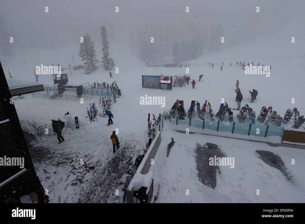 Mammoth Lakes, Kalifornien. 27. Februar 2023. Skifahrer und Snowboarder versammeln sich vor der Canyon Lodge während eines Schneesturms am Mammoth Mountain Ski Stockfoto