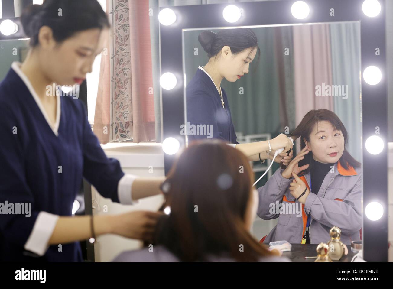NANTONG, CHINA - 7. MÄRZ 2023 - Studierende mit Hauptfach Flugmanagement an der Nantong Vocational University tragen Make-up für ihre Zimmerverwalterin zur Feier des Internationalen Frauentags in Nantong, Ostchina Provinz Jiangsu, 7. März 2023. (Foto: CFOTO/Sipa USA) Stockfoto