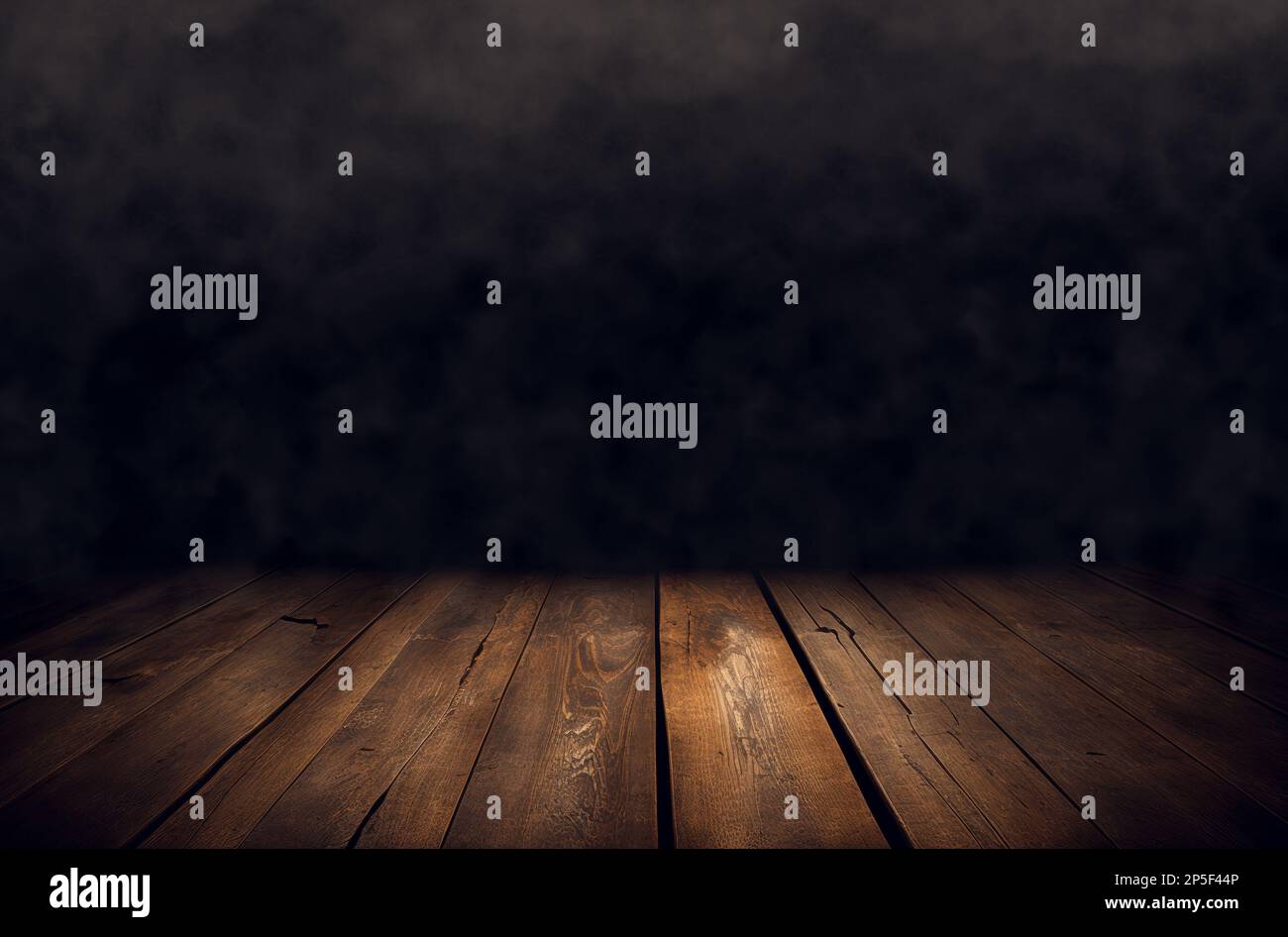 Leerer Holztisch mit Rauch schwebt auf dunklem Hintergrund Stockfoto