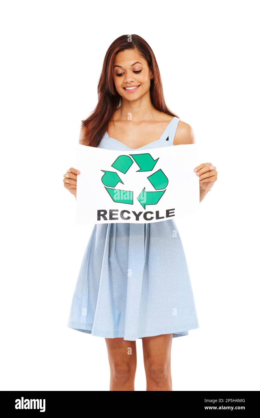 Sie behält das wichtige im Auge: Recycling. Junge Frau lächelt und hält ein Poster mit dem Recycling-Logo auf weißem Hintergrund hoch. Stockfoto