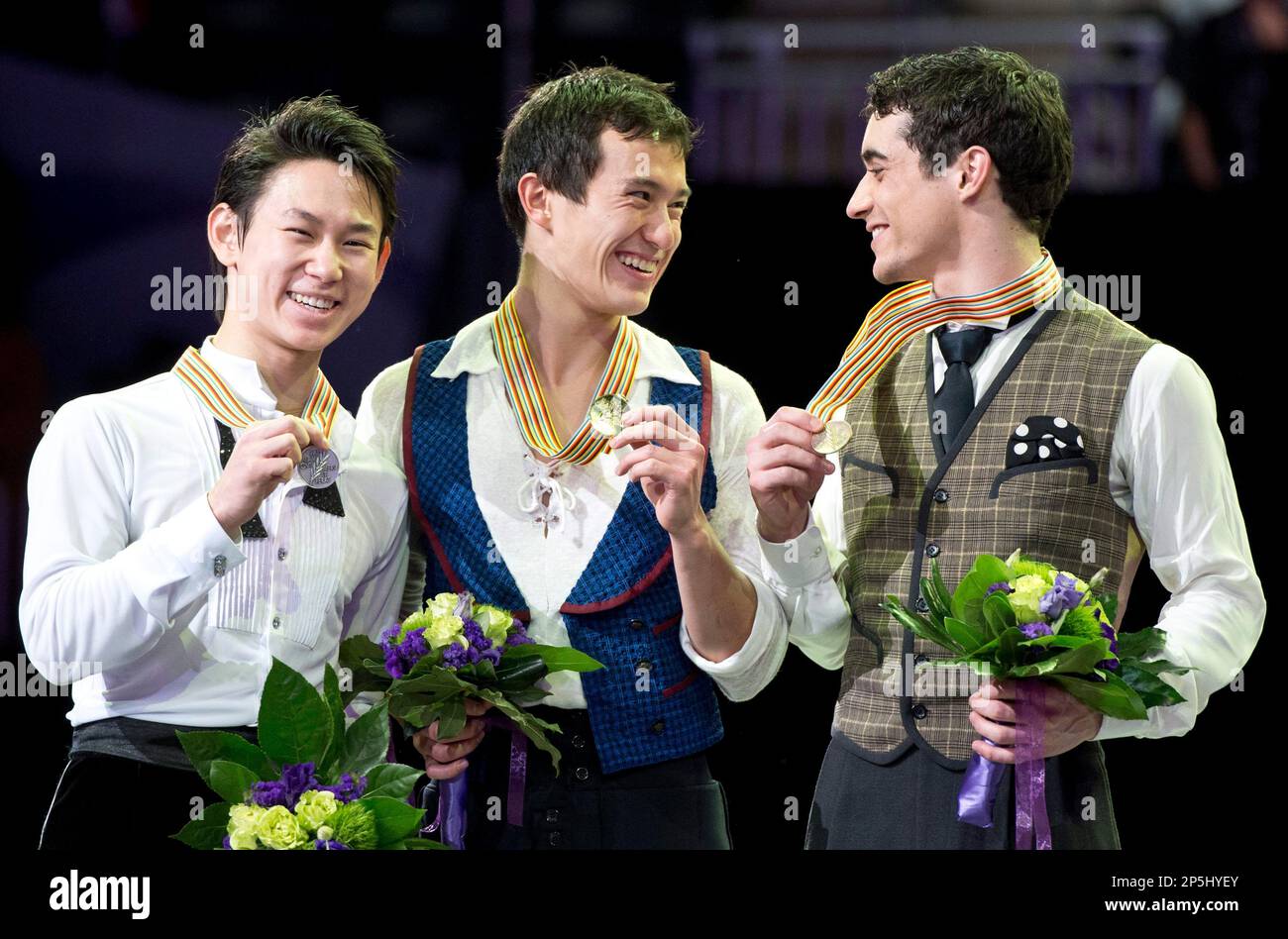 Gold medalist Patrick Chan, center, of Canada, flanked by silver medalist Dennis Ten, left, of Kazakstan, and bronze medalist Javier Fernandez, of Spain, show off their medals during the flower ceremony in the men's competition at the World Figure Skating Championships Friday, March 15, 2013 in London, Ontario. AP Photo/The Canadian Press, Paul Chiasson) Stockfoto