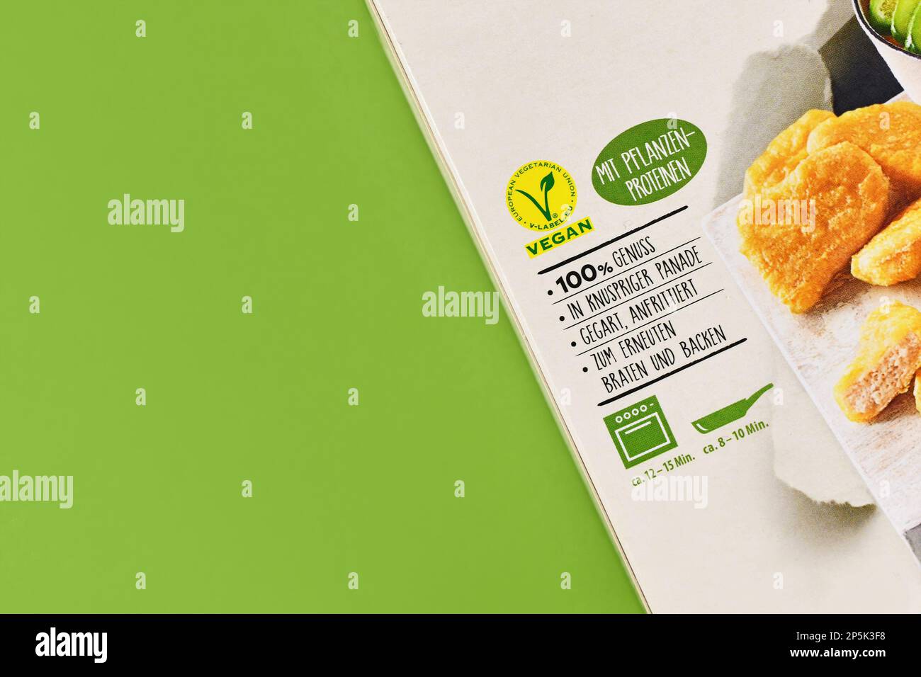 Deutschland - März 2023: Verpackung veganer Fleischersatzlebensmittel mit Etikett und deutschem Text auf grünem Hintergrund mit Kopierbereich Stockfoto