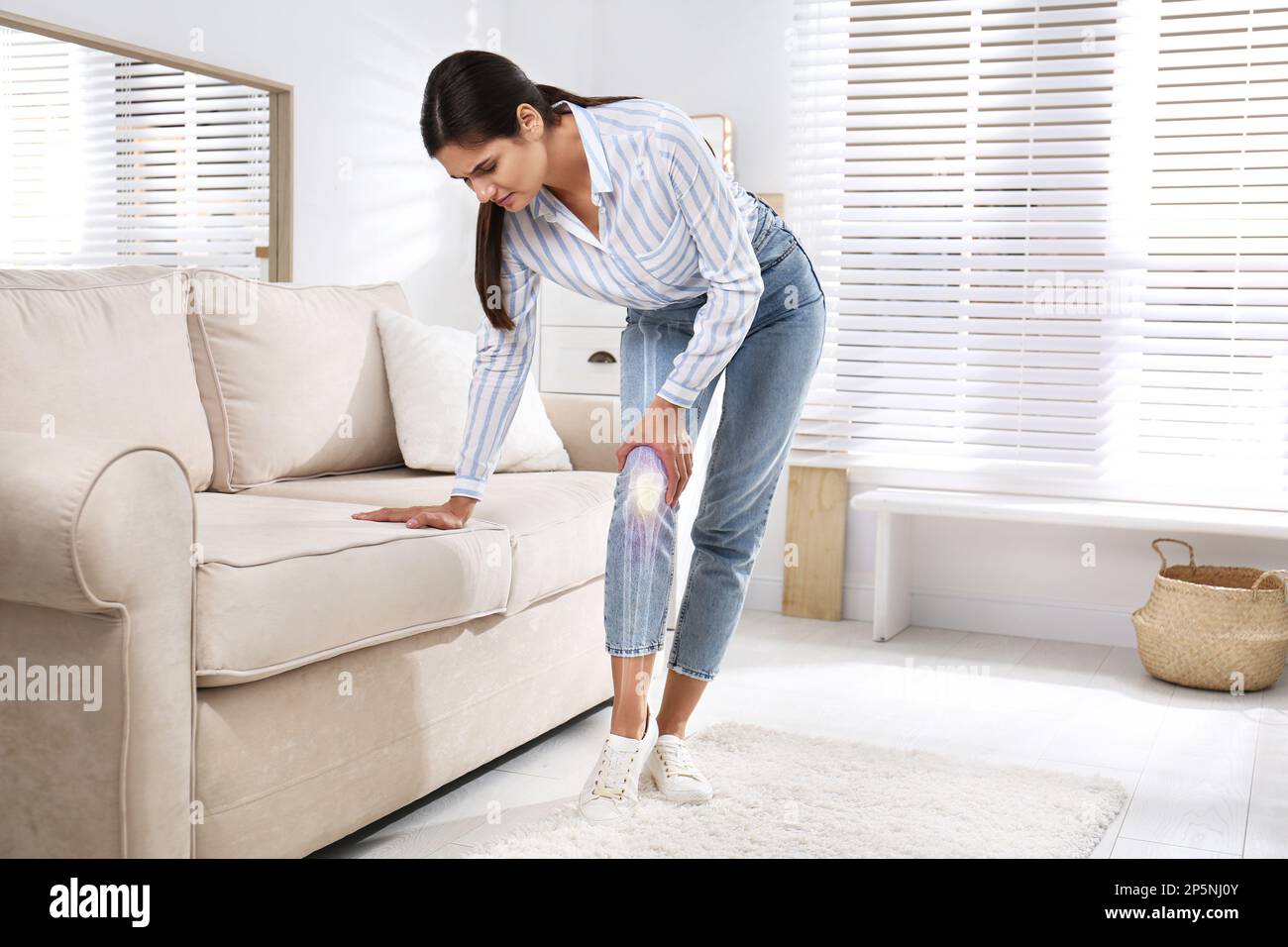 Eine kranke junge Frau zu Hause. Digitale Komposition mit Darstellung des Kniegelenkes Stockfoto
