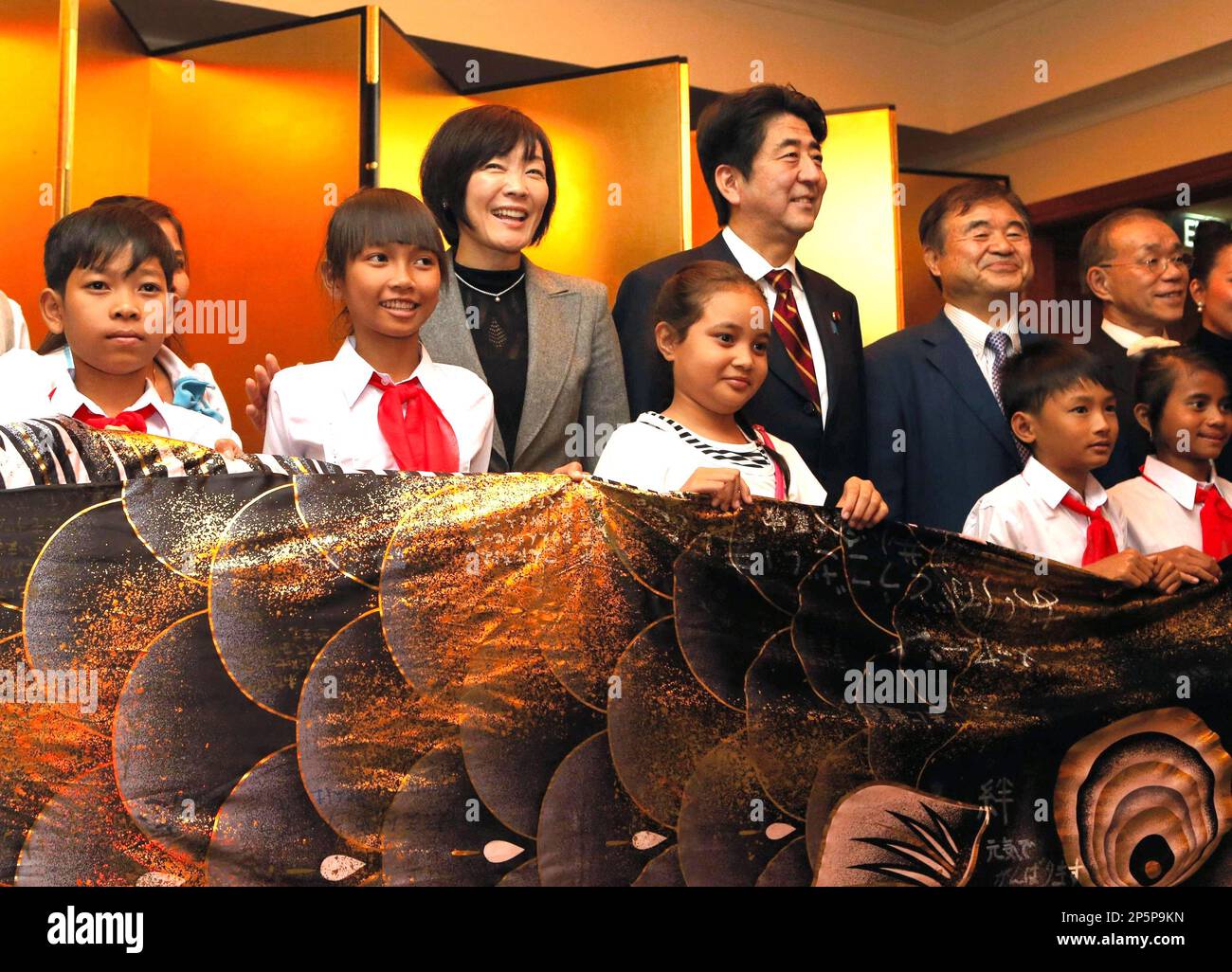 Japan's Prime Minister Shinzo Abe (C) and his wife Akie (L) are welcomed by pupils of a local Hanoi primary school in Vietnam on Jan. 16, 2013. Abe started his first leg of his three countries Asian visit since he returned to his office last December. ( The Yomiuri Shimbun via AP Images ) Stockfoto