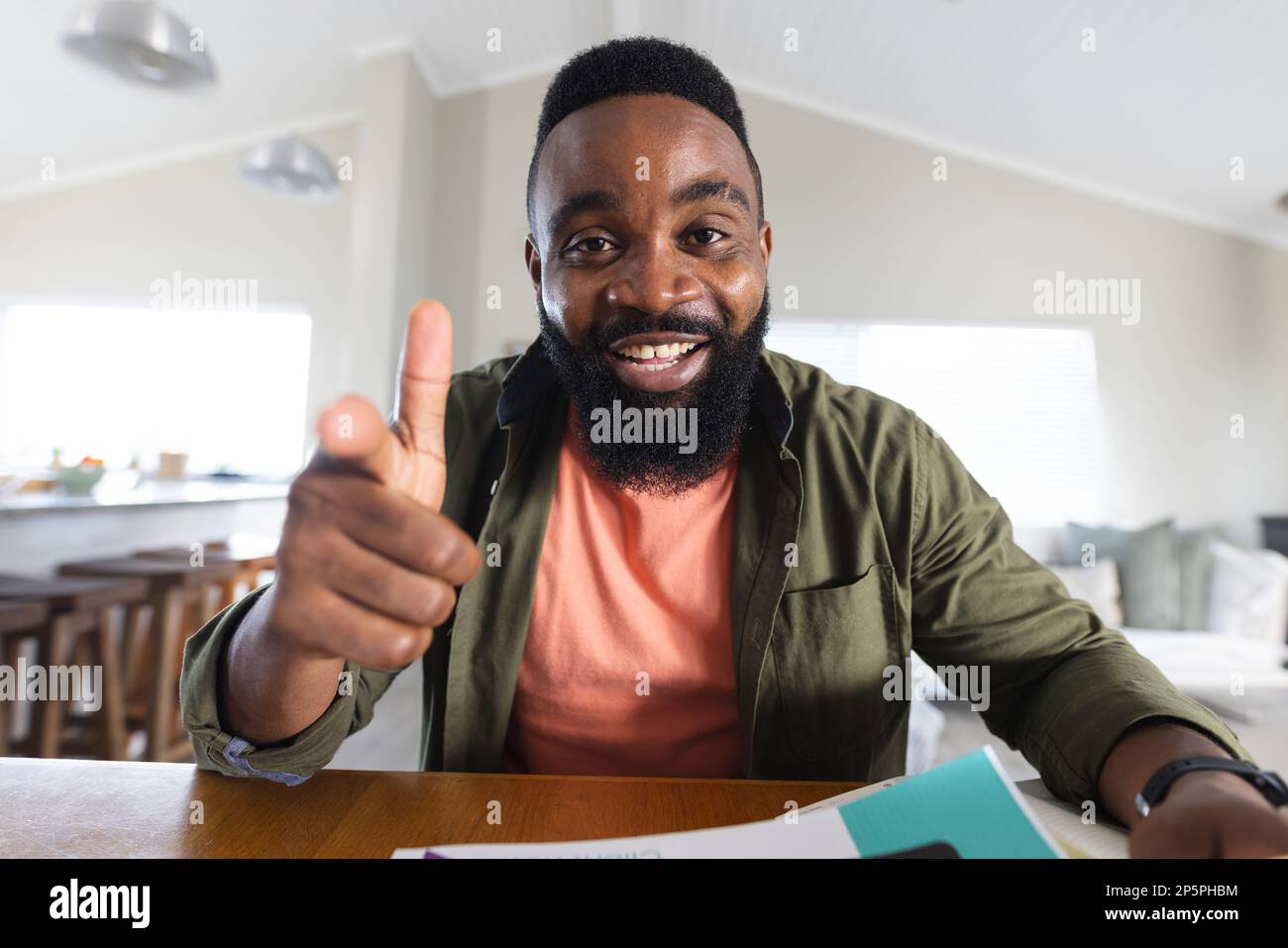 Ein glücklicher afroamerikanischer Mann, der Videoanruf hat und auf die Kamera zeigt Stockfoto