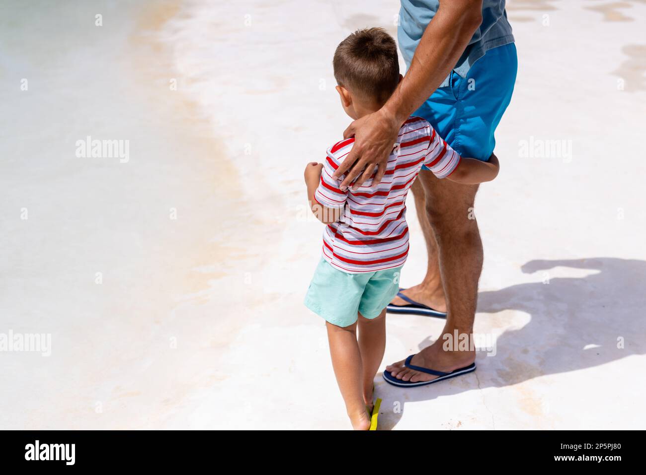 Fröhlicher, birassischer Vater und Sohn, die sich am Pool umarmen Stockfoto