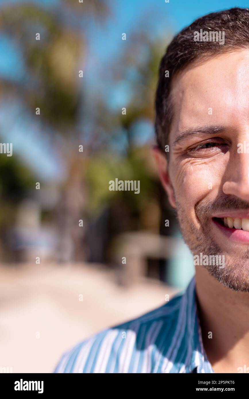 Porträt eines glücklichen weißen Mannes, der in die Kamera schaut und am Strand lächelt, mit Kopierraum Stockfoto