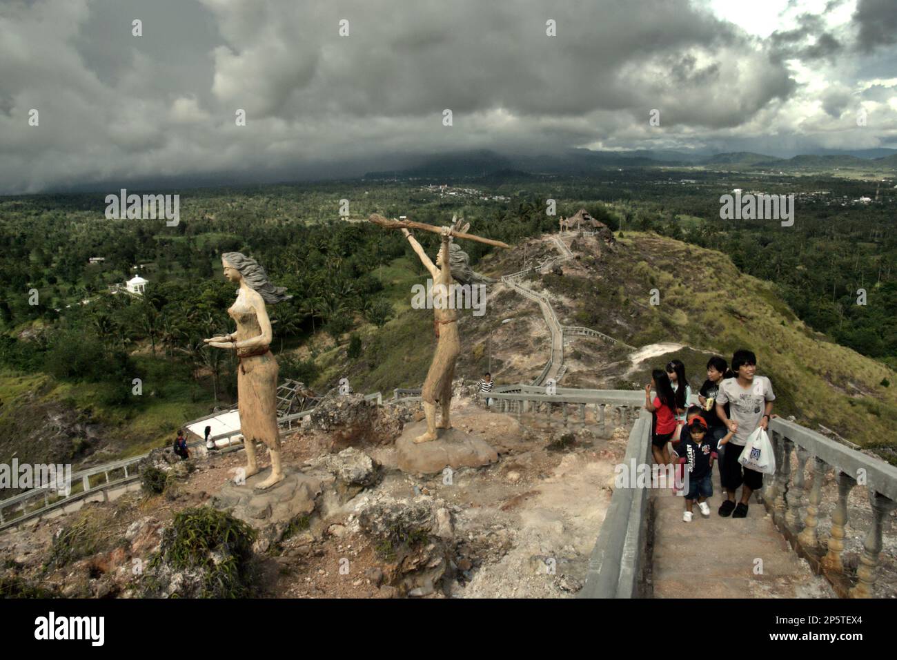 Besucher steigen auf Betontreppen, die zu einem flachen Gelände des Hügels führen, wo Gotteshäuser aller anerkannten Religionen in Indonesien auf Bukit Kasih (Hill of Love) gebaut werden, einem beliebten religiösen Reiseziel im Dorf Kanonang, West Kawangkoan, Minahasa, North Sulawesi, Indonesien. Gewidmet allen religiösen Gläubigen und Gläubigen, während sie die Geister der Liebe, des Friedens und der Toleranz fördern; Bukit Kasih wurde Anfang 2000 gegründet, als Adolf J. Sondakh Gouverneur der Provinz Nord-Sulawesi war. Stockfoto