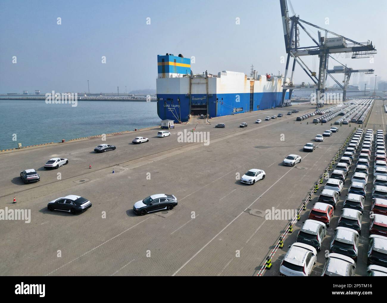 YANTAI, CHINA - 7. MÄRZ 2023 - Ein Transportschiff lädt Lastkraftwagen für den Export im Hafen von Yantai, ostchinesische Provinz Shandong, 7. März 2023. C Stockfoto