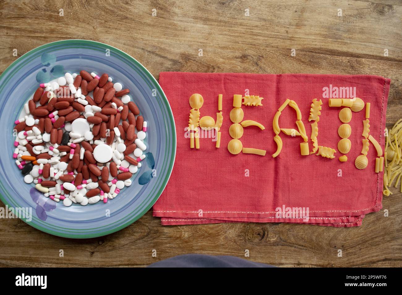 Wellness und Essen mit einem Teller voller Medikamente und das Wort Gesundheit hergestellt mit Pasta Stockfoto