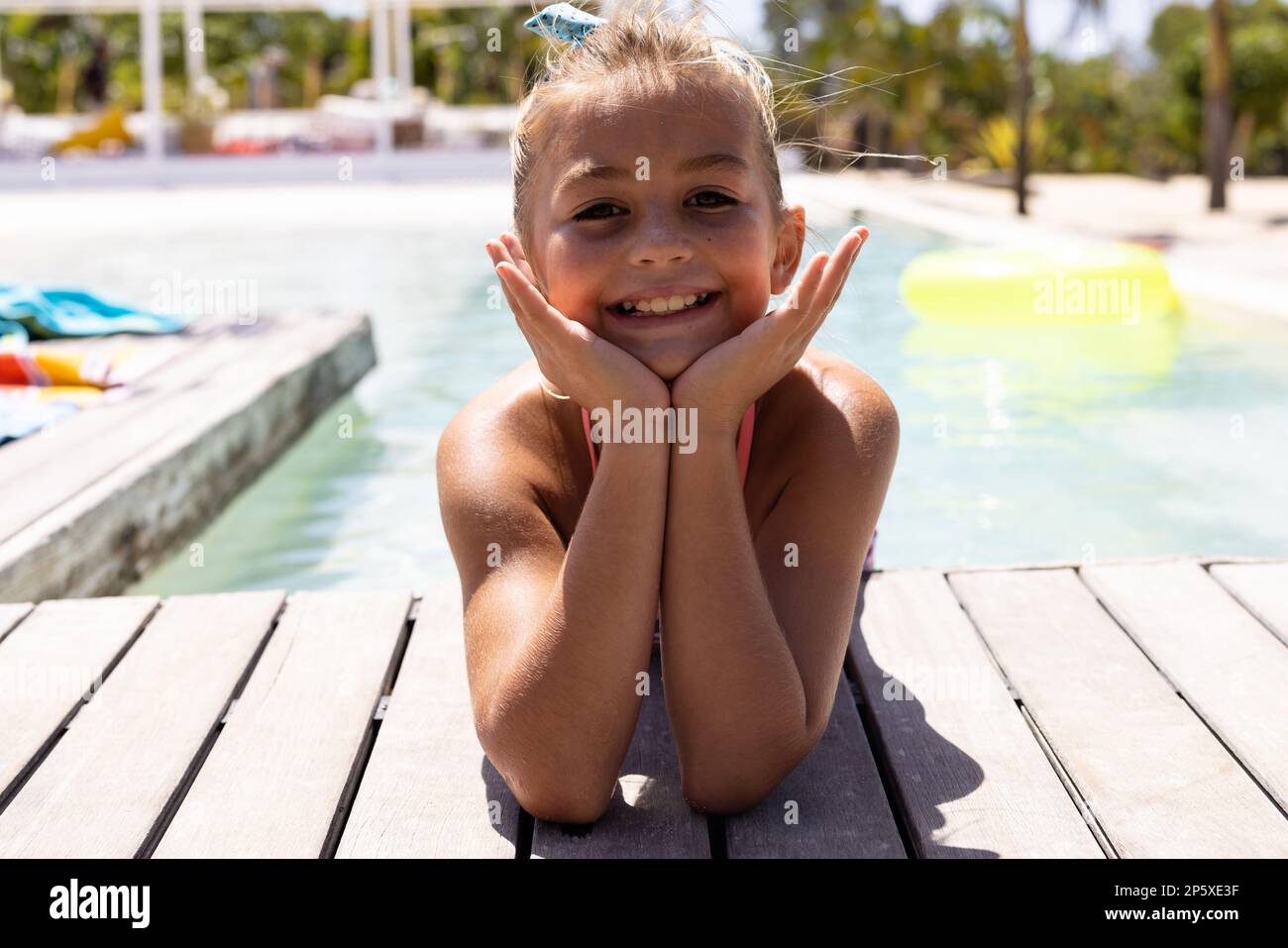 Porträt eines glücklichen, birassischen Mädchens, das am Pool lächelt Stockfoto
