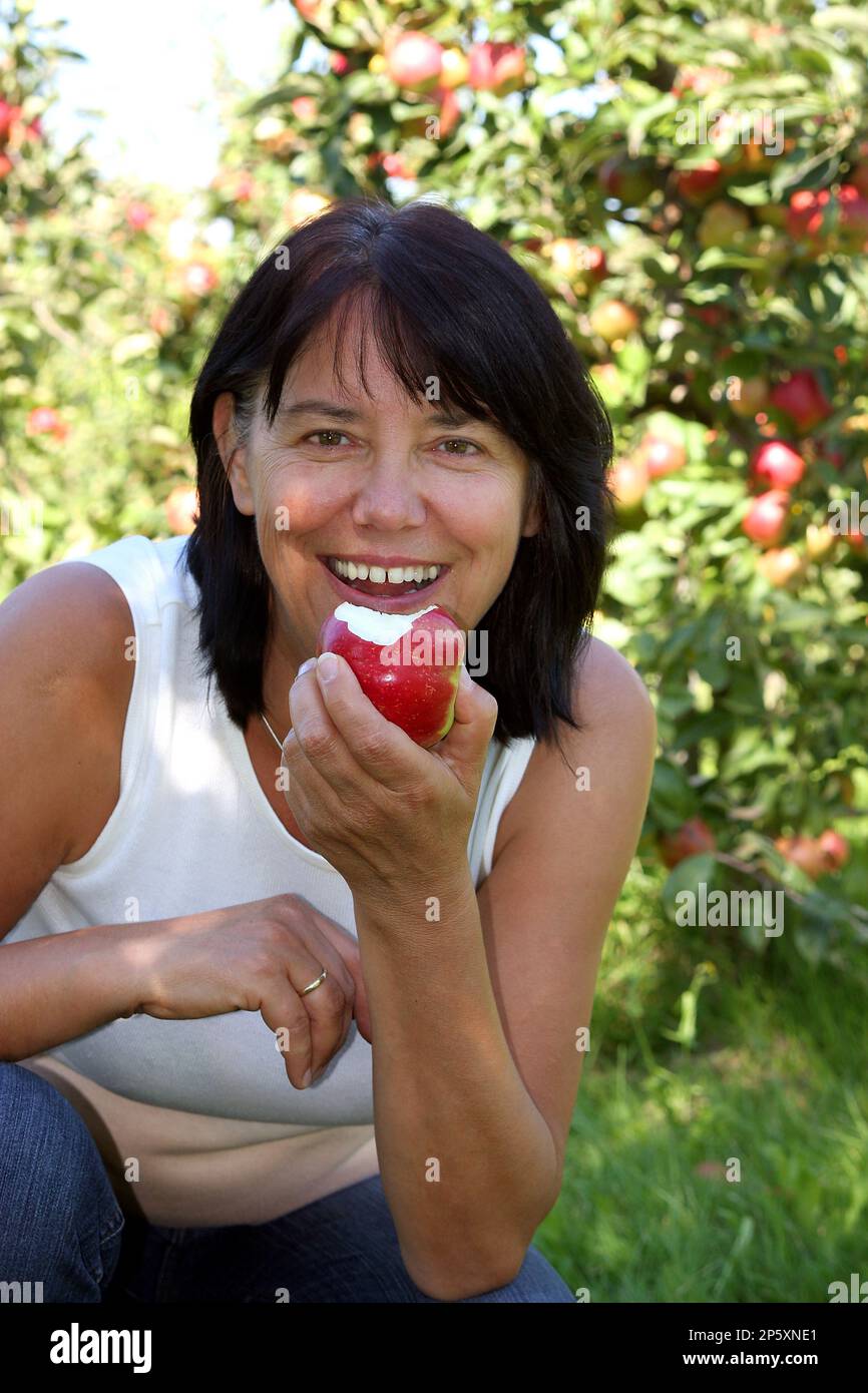 apfel (Malus domestica), Frau, die einen köstlichen Apfel isst Stockfoto