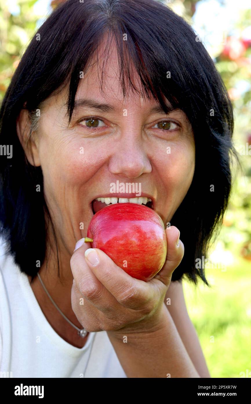 apfel (Malus domestica), Frau, die einen köstlichen Apfel isst, Porträt Stockfoto