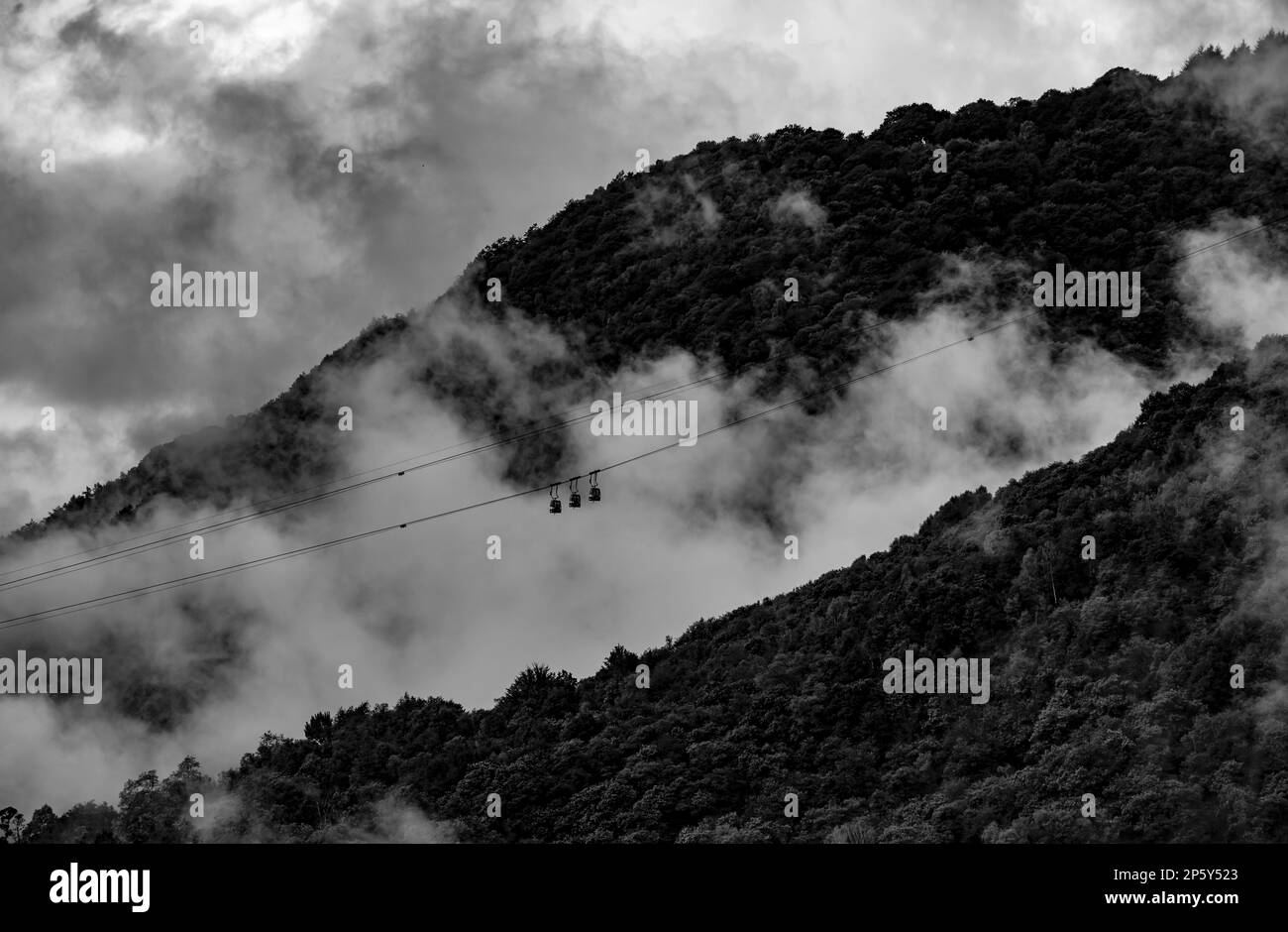 Bergbahn mit Wolken und Sonnenlicht in Miglieglia, Tessin, Schweiz. Stockfoto
