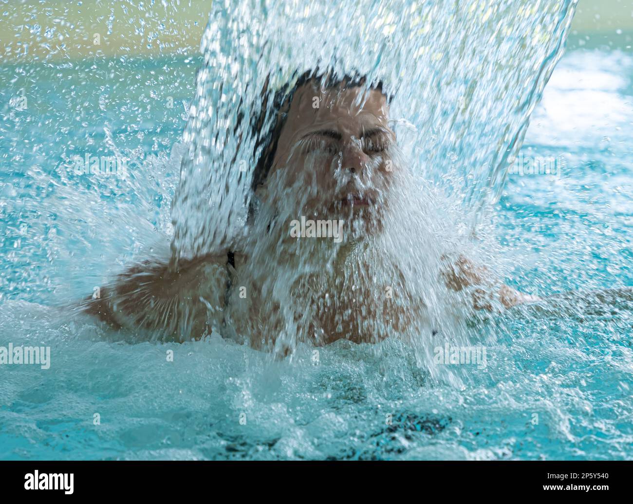 Frauengesicht Entspannen in einem Hydromassage-Pool mit fallendem Wasser in der Schweiz. Stockfoto