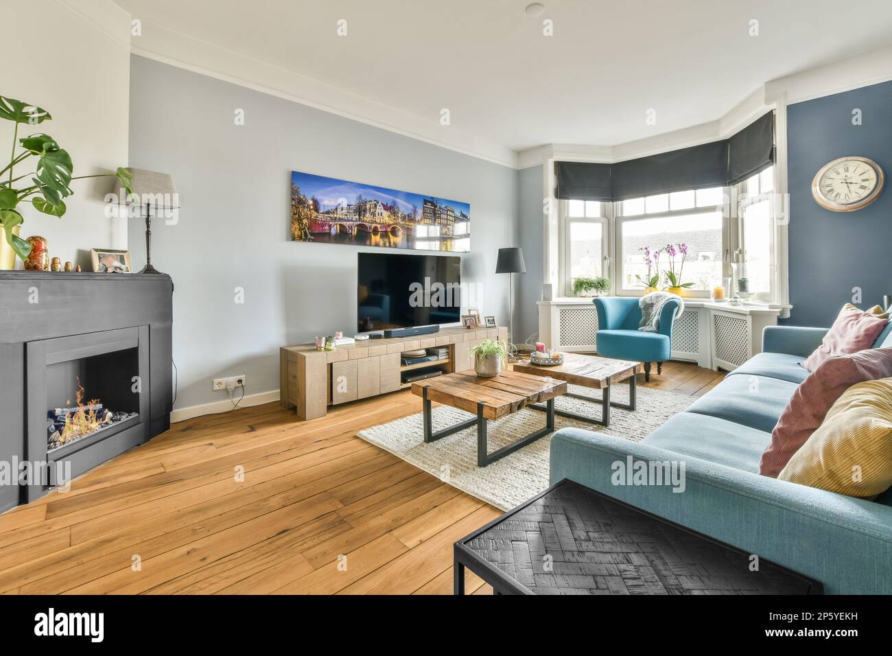 Ein Wohnzimmer mit blauen Sofas und einem fernseher an der Wand vor dem  Kamin, umgeben von einem Stockfotografie - Alamy