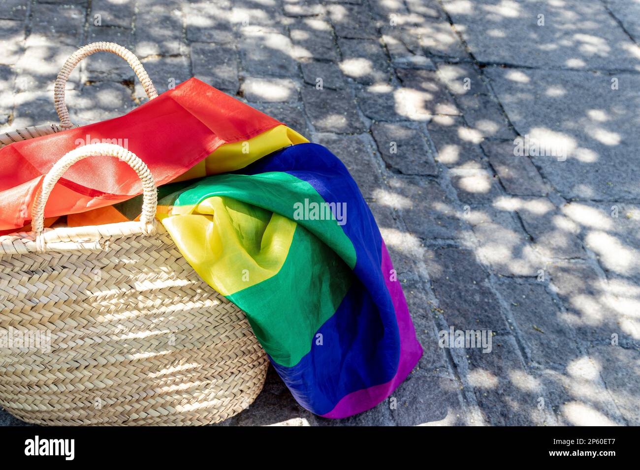 LGBT-Regenbogenfahne in einem Korb auf dem Boden. Schwulenparade, Freiheit, Toleranz Stockfoto