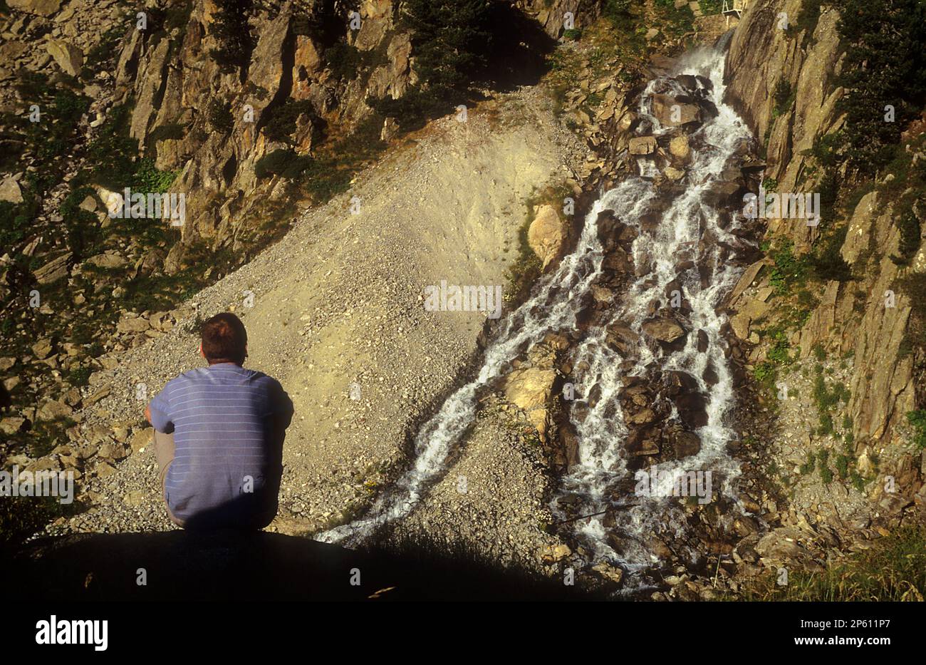 Tripper und Wasserfall, in der Nähe des Obago-Sees, Colomèrs cirque, Aran Valley, Aigüestortes und Estany de Sant Maurici National Park, Pyrenäen, Lleida Prov Stockfoto