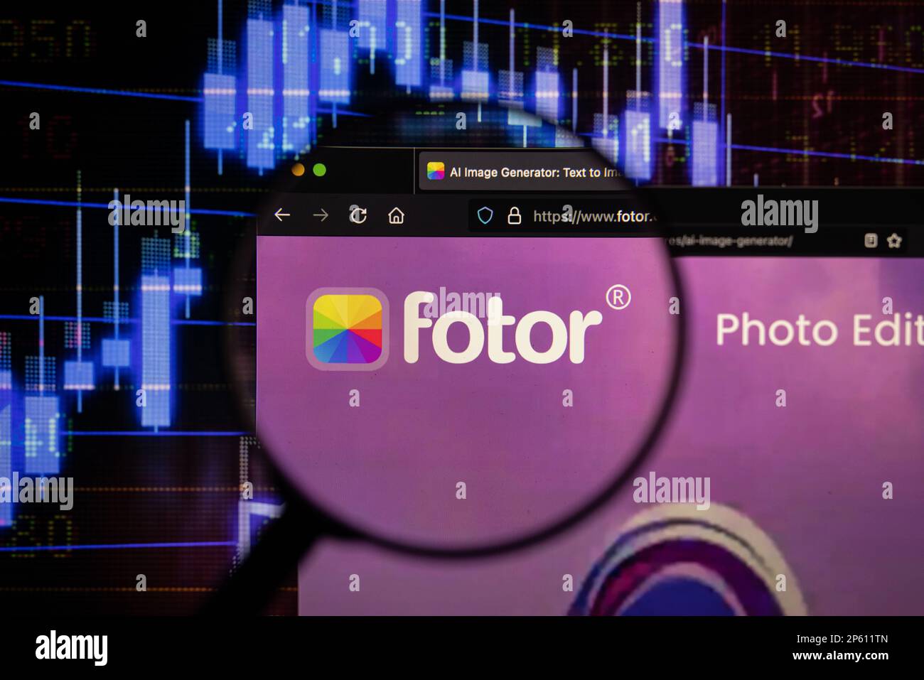 Fotor Firmenlogo auf einer Website mit verschwommenen Aktienmarktentwicklungen im Hintergrund, auf einem Computerbildschirm durch eine Lupe zu sehen Stockfoto