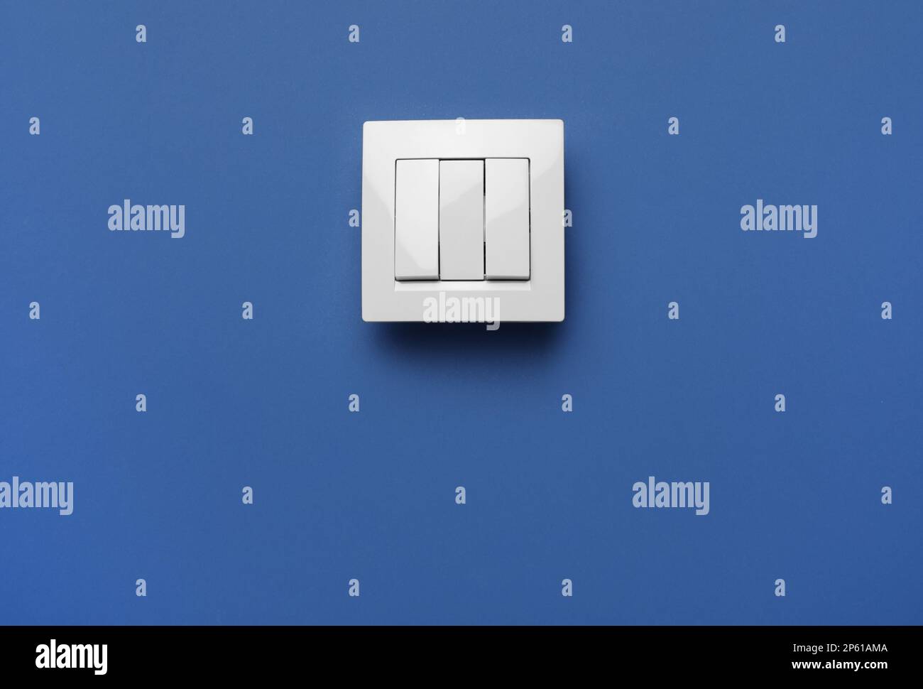 Moderner Lichtschalter aus Kunststoff auf blauem Hintergrund. Platz für  Text Stockfotografie - Alamy